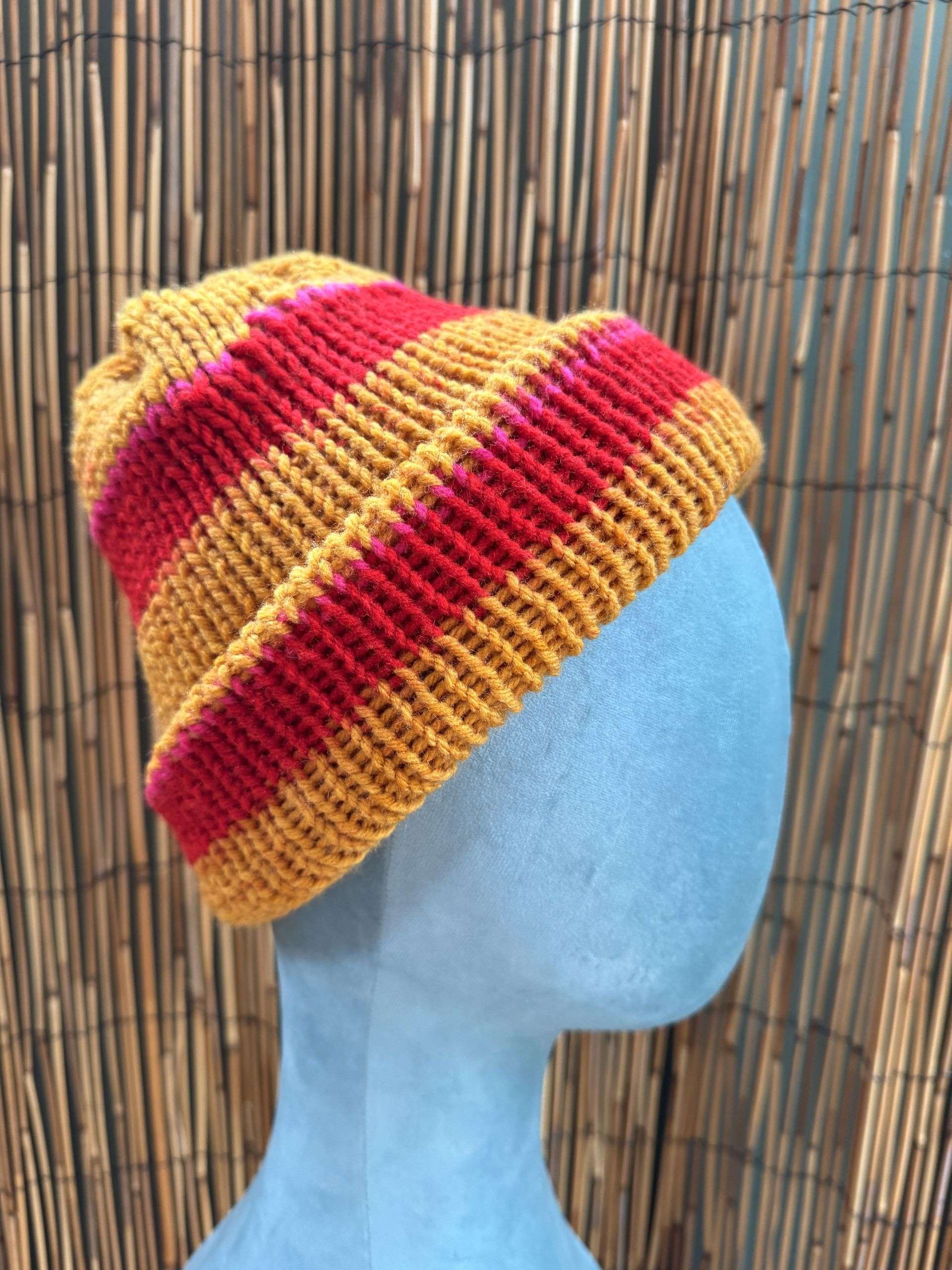 Bold gold and red stripes make this handknitted beanie one of our sunniest adult beanies for winter.