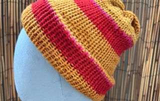Our red and orange striped beanie handknitted for anyone who likes their winter warmth with a bit of fire.