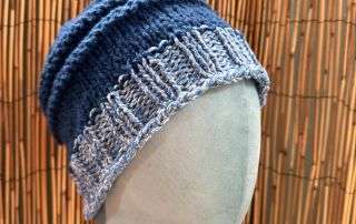 Close up of the blue and white panels on this handmade knitwear beanie, crisp as a winter sky.