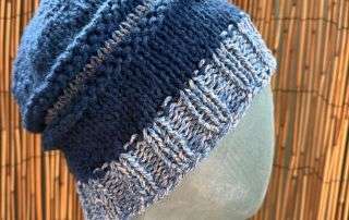 Close up of the blue and white panels on this handmade knitwear beanie, crisp as a winter sky.