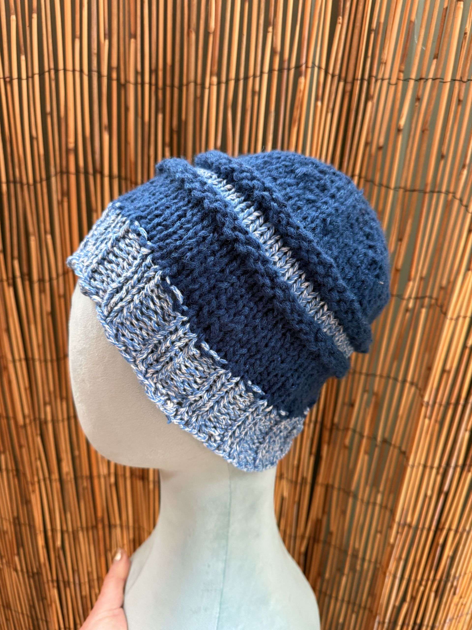 A slouchy blue and white adult beanie, handknitted in panels for a relaxed, storybook silhouette.