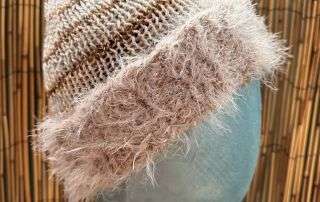 A creamy handknitted beanie with a fluffy contrast brim, one of our cosiest adult beanies for winter walks.