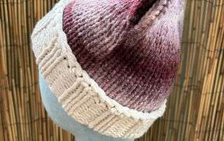 Side view of our berry marl cat ear beanie, cream cuffed and ready for anyone who never grew out of make believe.