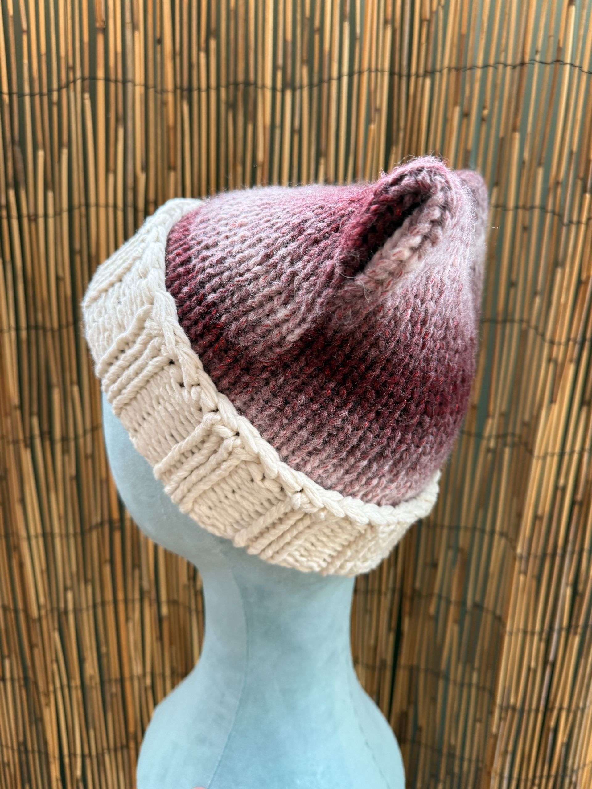 Side view of our berry marl cat ear beanie, cream cuffed and ready for anyone who never grew out of make believe.