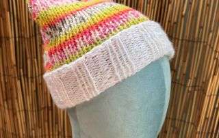 A playful pink and yellow cat ear beanie, cream cuffed and handknitted for the cat lovers among us.