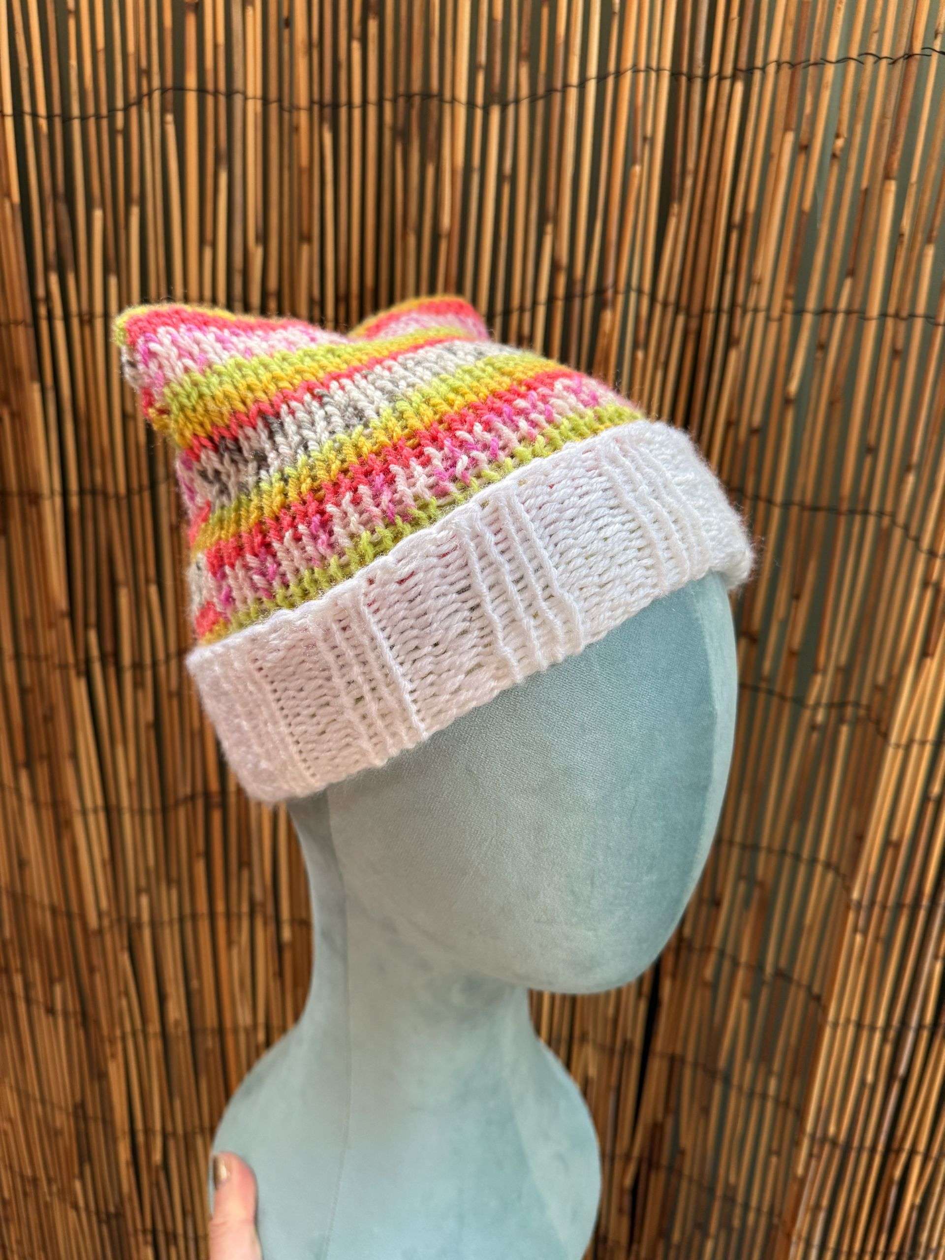 A playful pink and yellow cat ear beanie, cream cuffed and handknitted for the cat lovers among us.