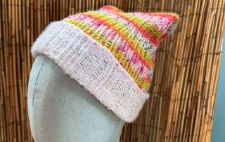 A playful pink and yellow cat ear beanie, cream cuffed and handknitted for the cat lovers among us.