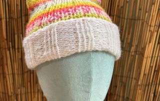 Two perky ears and a rainbow of pink and yellow stripes, this cat ear beanie is handknitted pure whimsy.
