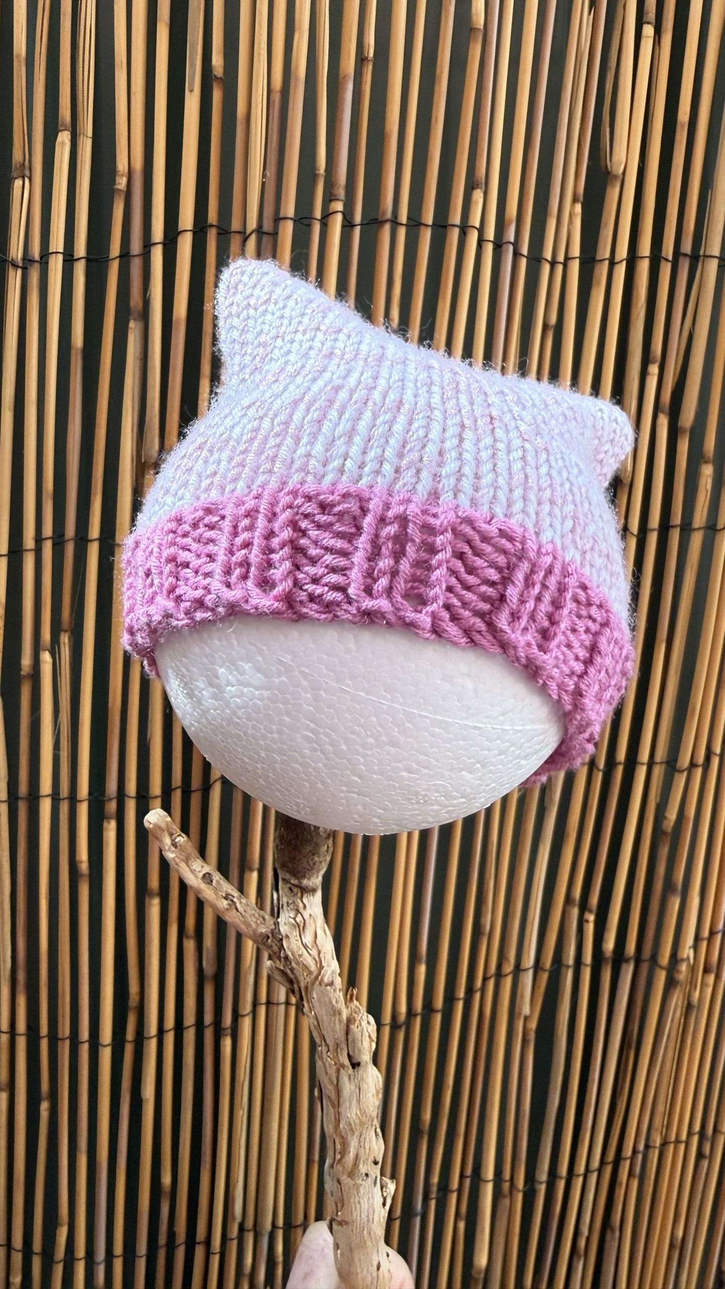 A soft baby pink cat ear beanie handmade with a deeper pink ribbed cuff, whimsical enough for the tiniest cat lovers.
